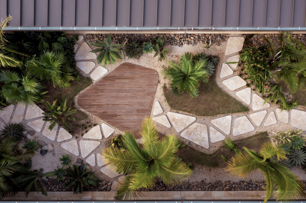 Overhead view of the courtyard's wooden deck and stone paths among tropical planting.